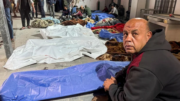 Man Sitting Near Covered Bodies Israeli